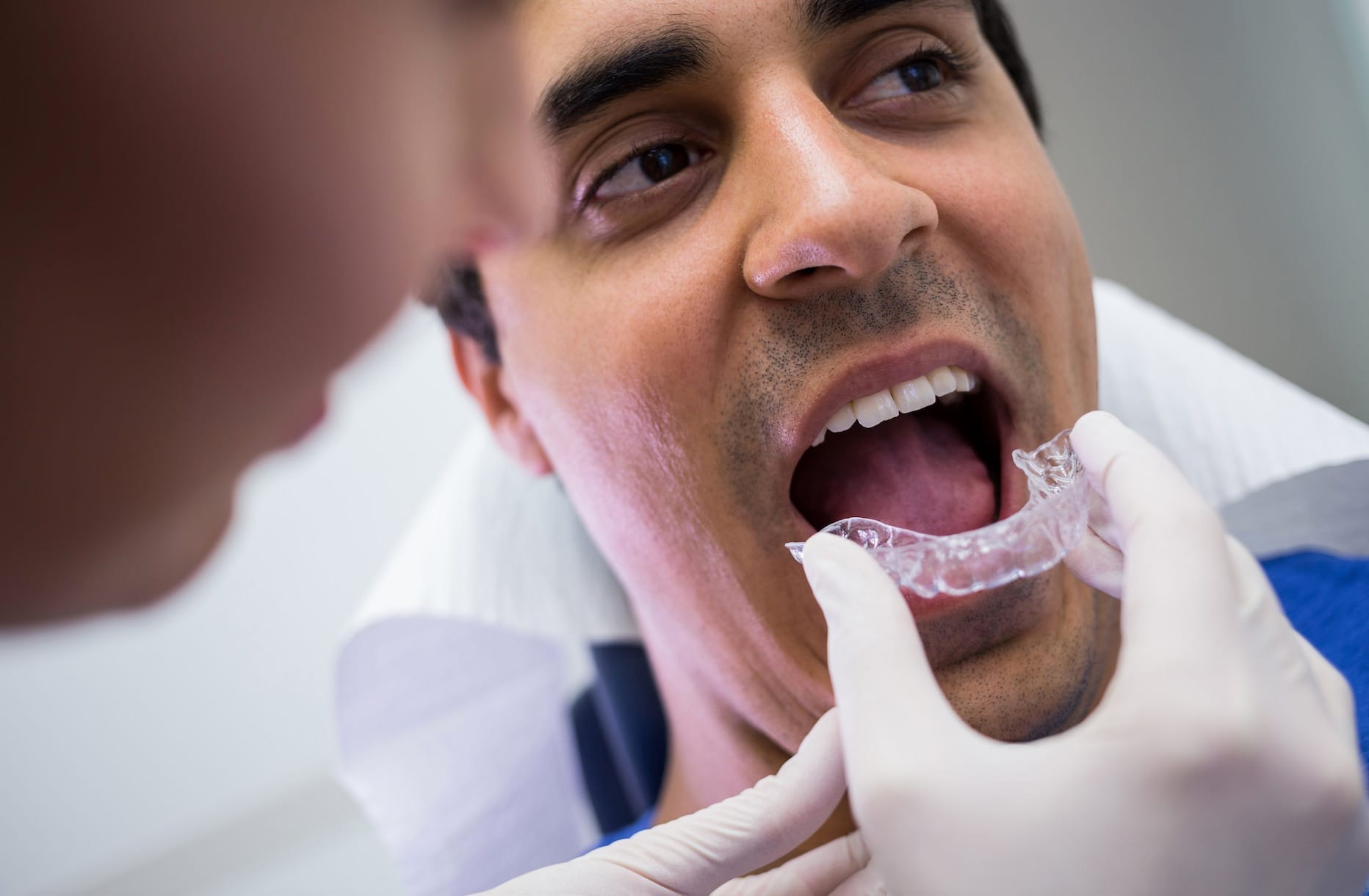 Dentist fitting patient with clear aligners Dentist fitting patient with clear aligners