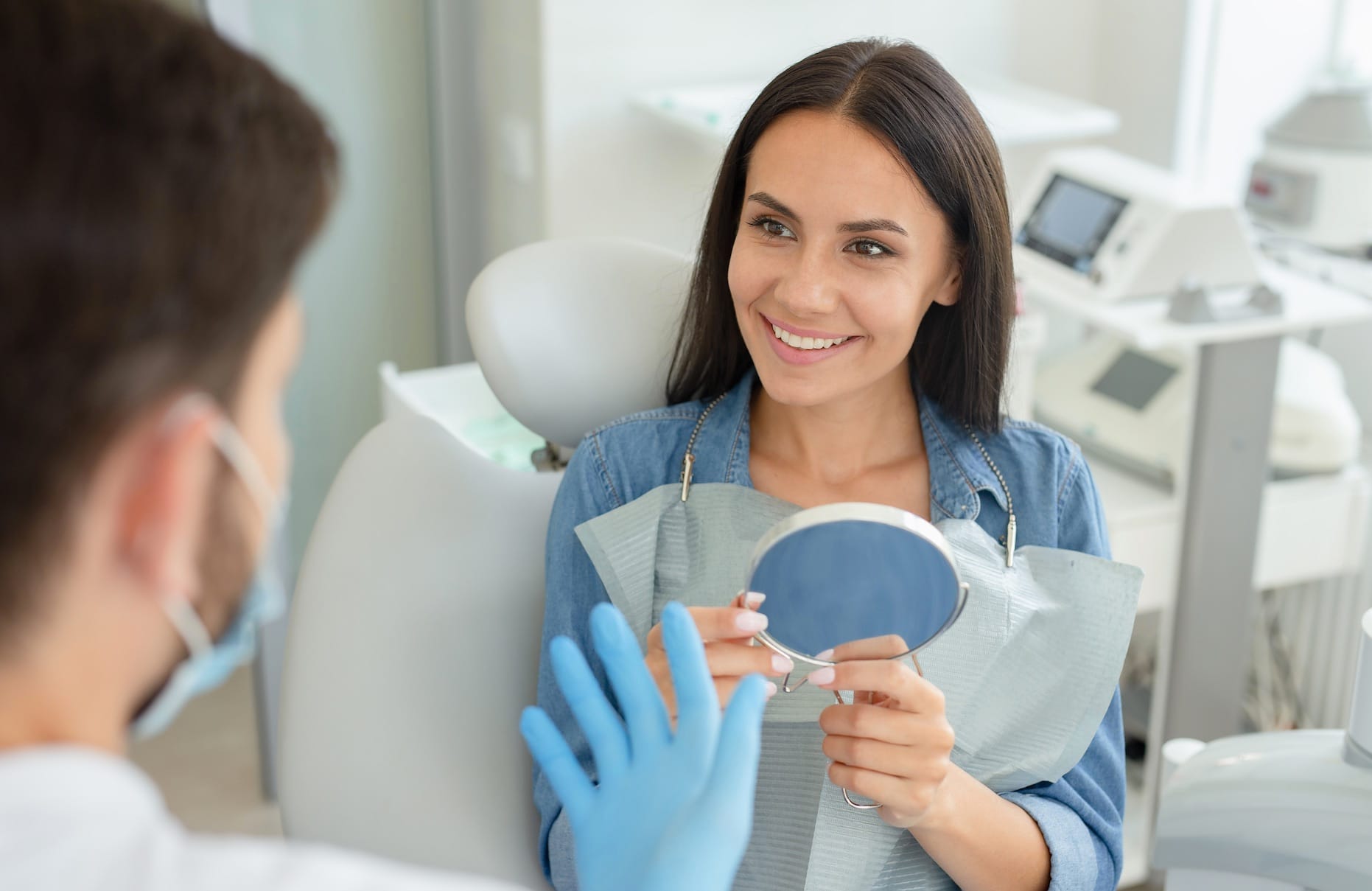 Smiling woman checks teeth in mirror Smiling woman checks teeth in mirror